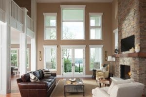 Is Fibrex® Waterproof? Lofty living room with brick fireplace, vaulted ceilings, and white-frame windows overlooking yard.