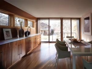 Patio Doors Appleton WI Spacious dining area with wooden floors, wooden cabinetry, and patio doors that lead to a backyard space.