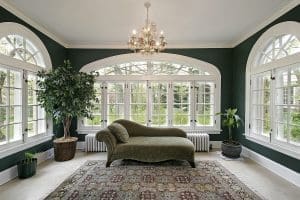 Sunroom in luxury home with sofa and wall of windows