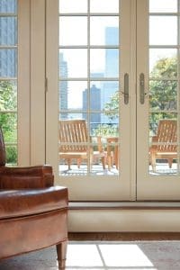 Interior of residence featuring white French patio doors that lead out to outdoor living area.